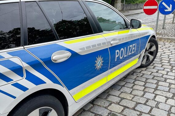 Unfallstelle mit Auto im Hang, Polizei vor Ort, verletzte Fahrerin und zwei Kinder.