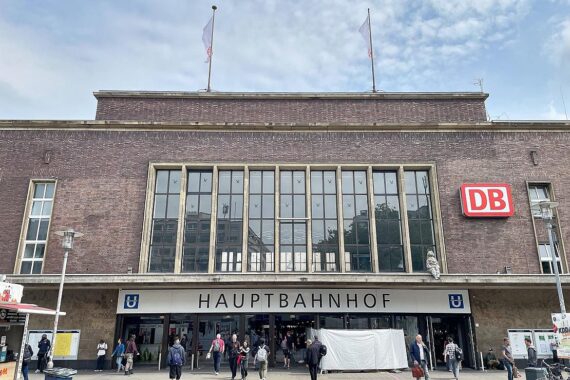 Düsseldorfer Hauptbahnhof mit Zügen, Baustellen und Techniker, die Kabelreparaturen durchführen.