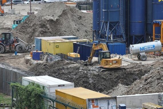 Baustelle mit Bauarbeiten, Kranen und Baugeräten, symbolisiert Anstieg der Auftragseingänge im Baugewerbe.