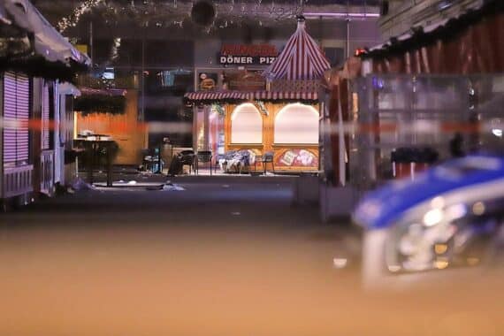 Ein Bild des Weihnachtsmarkts in Magdeburg, mit Sicherheitsmaßnahmen und besorgten Besuchern.