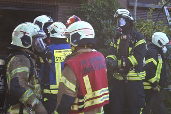Intensives Feuer in Einfamilienhaus, Feuerwehr im Einsatz, starker Rauch, zerbrochenes Fenster.