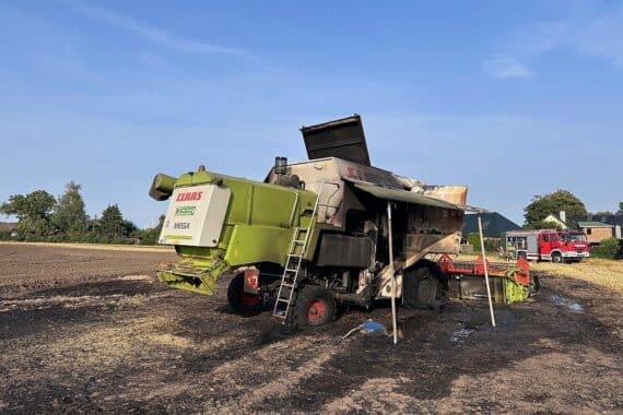 Erntemaschine brennt, Feuerwehr im Einsatz, Weizenfeld betroffen, große Schäden durch Feuer.