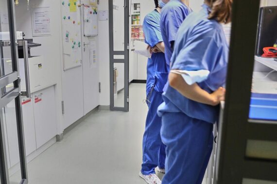 Medizinisches Personal beurteilt Krankenhausleistungen, symbolisiert durch Ärzte und Patienten in einer Klinik.