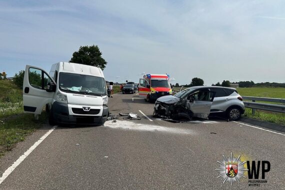 Unfallstelle mit Polizei und Rettungsdienst, beschädigte Autos, verletzte Personen werden versorgt.
