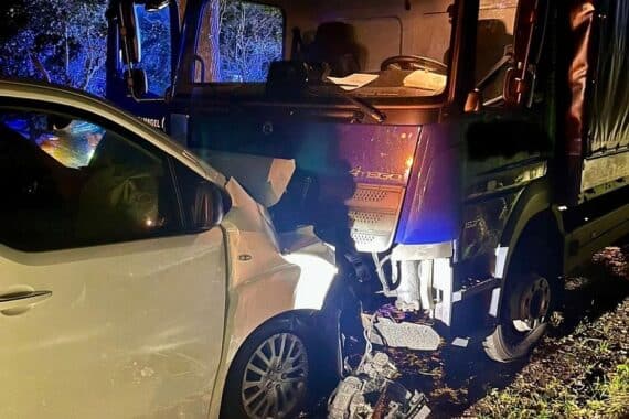 Verunfallter Pkw und Lkw nach frontalem Zusammenstoß, Rettungskräfte sichern Unfallstelle.