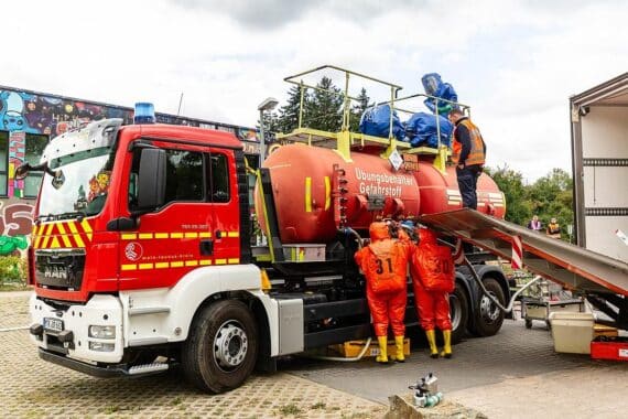 Einsatzkräfte üben gemeinsam den Umgang mit Gefahrstoffen in Chemikalienschutzanzügen unter realistischen Bedingungen.
