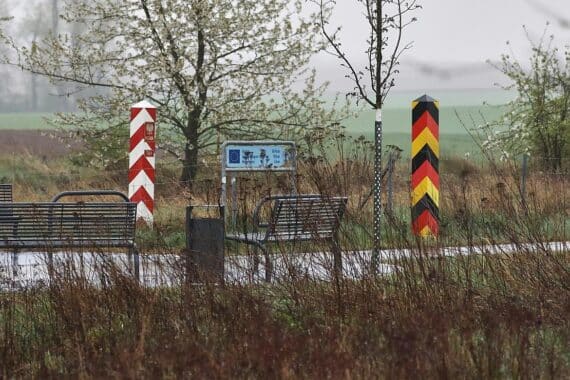 Grenze zwischen Polen und Deutschland mit Pendlern, symbolisiert durch Straßen oder Verkehrszeichen.