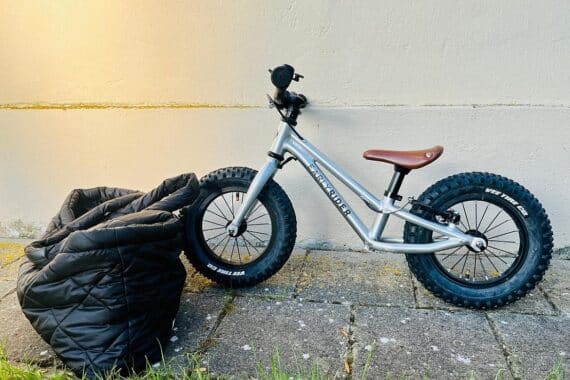 Silbernes Kinderlaufrad und schwarze Damen-Tasche; beide Gegenstände am Autobahndreieck gefunden.