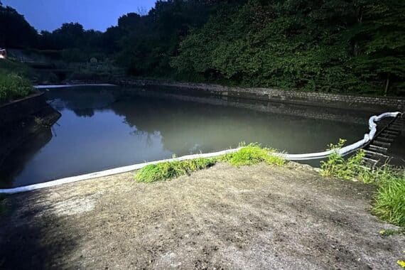 Ölsperren und Feuerwehr im Einsatz zur Bekämpfung von Umweltschäden nach LKW-Brand.