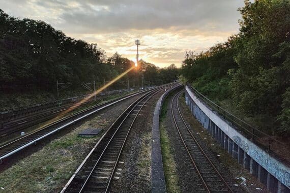 S-Bahn-Gleise mit einem Kabelschacht, Warnung vor Gefahren an Bahnanlagen, Sicherheitsaspekt.