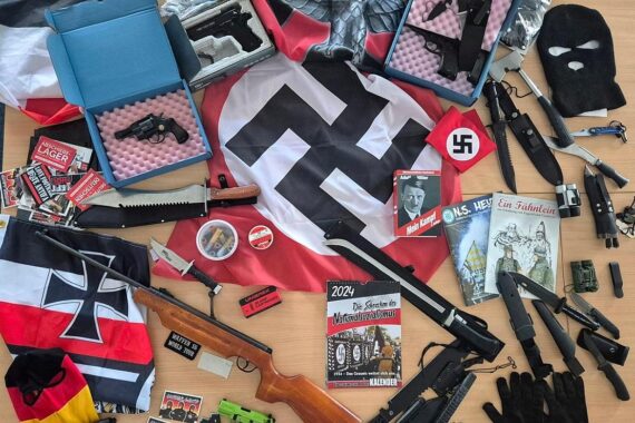 Polizei durchsucht Wohnungen, sichergestellte Waffen und rechtsextremes Propagandamaterial sichtbar.