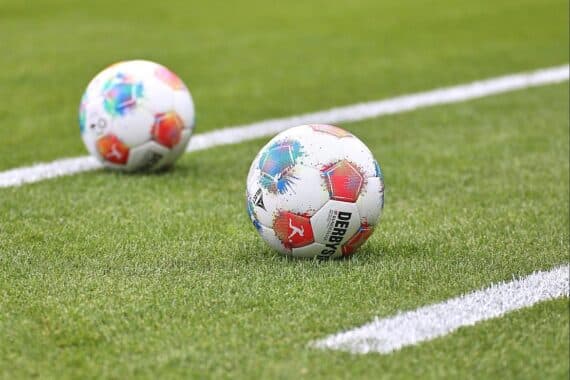 Fußbälle vor einem Stadion, symbolisch für das bevorstehende Regionalliga-Spiel mit Polizeieinsatz.