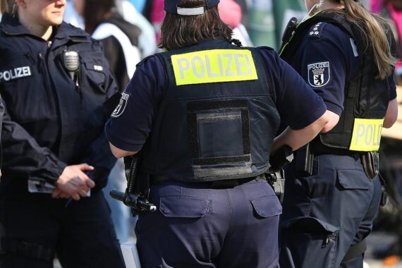 Polizisten beobachten eine Gruppe Männer, nachdem Zeugen Hitlergruß gemeldet haben.