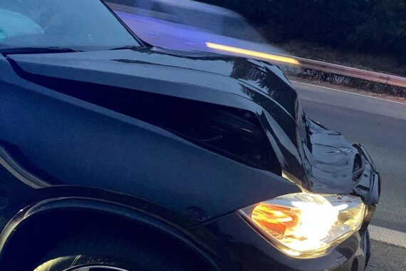 Unfallauto nach Kollision auf Autobahn, Polizei vor Ort, verletzter Fahrer ins Krankenhaus.