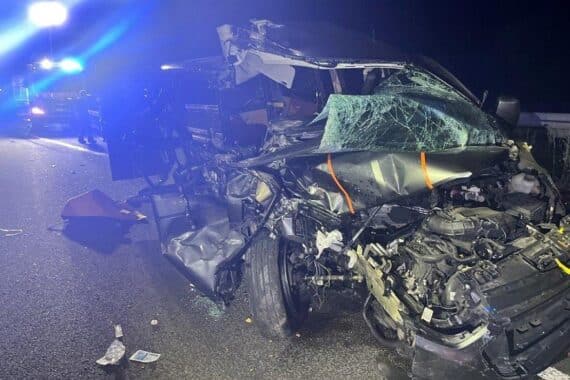Zerstörter Kleinbus nach Unfall auf Autobahn, Einsatzkräfte und Verletzte, klarer Unfallort.