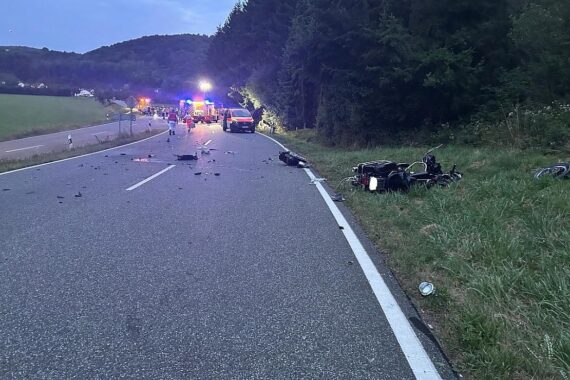 Motorrad und Pkw nach schwerem Unfall auf Bundesstraße 420. Rettungskräfte im Einsatz.