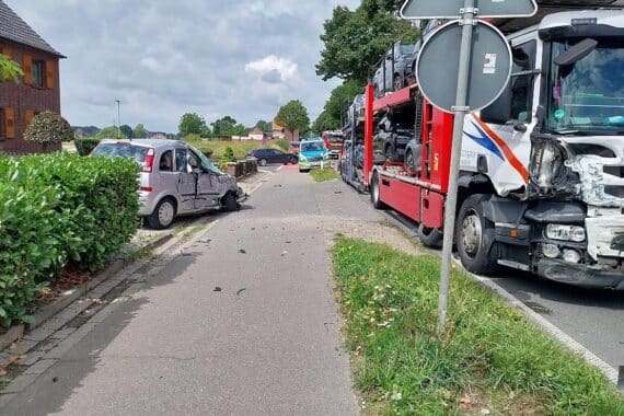 Schwerer Verkehrsunfall zwischen Lkw und Pkw, Feuerwehr im Einsatz, verletzter Autofahrer, Unfallstelle gesperrt.