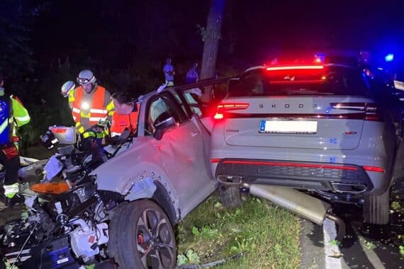Schwerer Autounfall: zerstörter PKW, Baum, Unfallstelle, Rettungskräfte, Polizei untersucht Unfallursache.