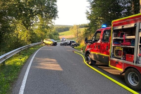 Schwerer Verkehrsunfall mit zwei Fahrzeugen, Rettungskräfte und Polizei im Einsatz auf Landesstraße.