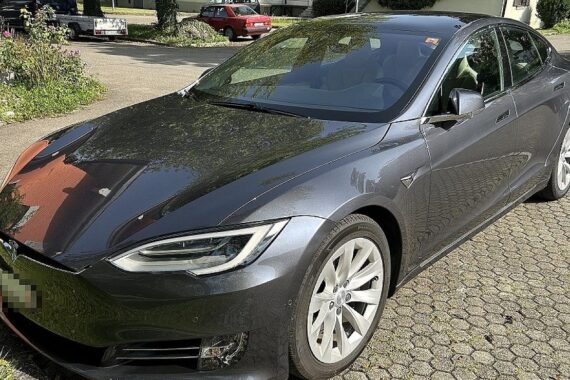 Tesla Model S mit Schweizer Kennzeichen, Zollbeamte überprüfen Einfuhrabgaben an der Autobahn.
