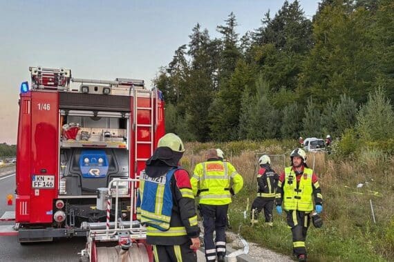 Unfallfahrzeug in der Böschung, Feuerwehr und Polizei sichern die Unfallstelle.