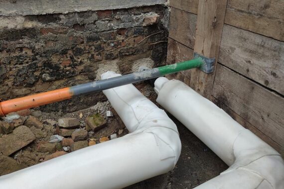 Eine Person installiert eine Wärmepumpe in einem modernen, ökologischen Wohnhaus.