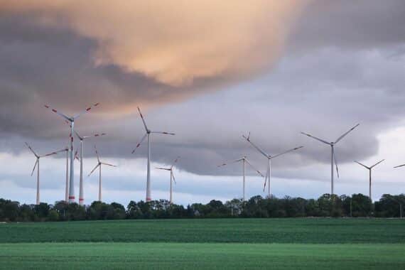 Bedeckte Himmel über Windrädern, die Regen und wechselhaftes Wetter in Bayern symbolisieren.