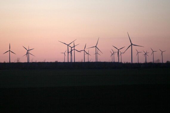 Windräder vor einem blauen Himmel, symbolisieren angenehmes Wetter in Nordrhein-Westfalen.