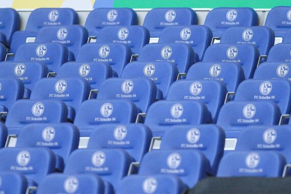 Leere Stadion-Sitze mit FC Schalke 04-Logo, symbolisieren enttäuschten Fans nach Niederlage.