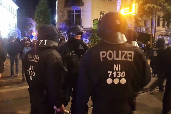 Unfallstelle mit zerstörtem Kleinwagen und Einsatzkräften der Feuerwehr an der Straße.