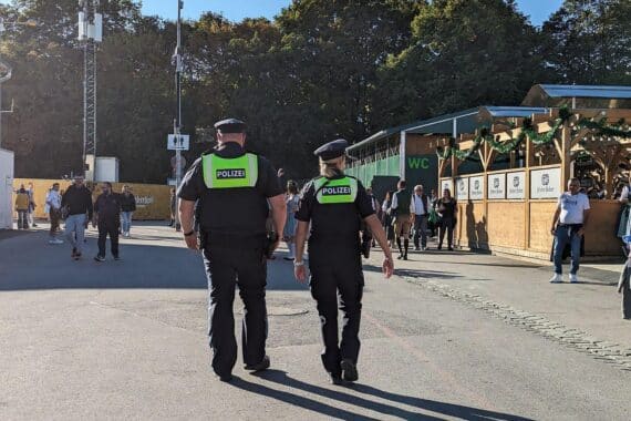Oktoberfest-Szenen mit Menschen, Polizei und Feierlichkeiten, um die Sicherheit und Ereignisse darzustellen.