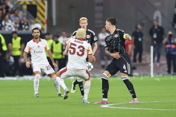 Eintracht Frankfurt-Fans an Bahnhof, Pyrotechnik und Sicherheitskräfte während Champions-League-Spiel.