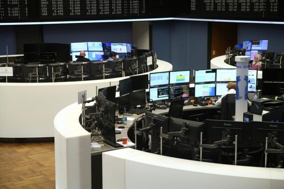 Dax-Chart mit aufsteigenden Kurven, Börsenmonitor und Grafiken von Unternehmensgewinnen und Wirtschaftsdaten.