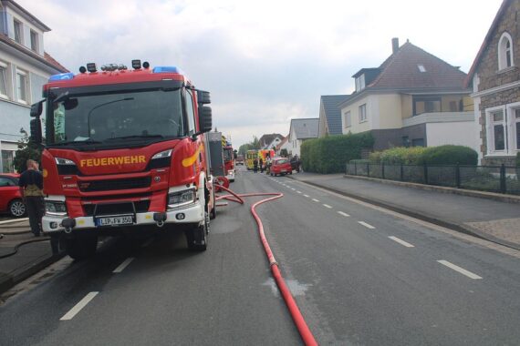 Brand in Bad Salzuflen: Feuerwehr im Einsatz, Straße gesperrt, verletzte Personen evakuiert.