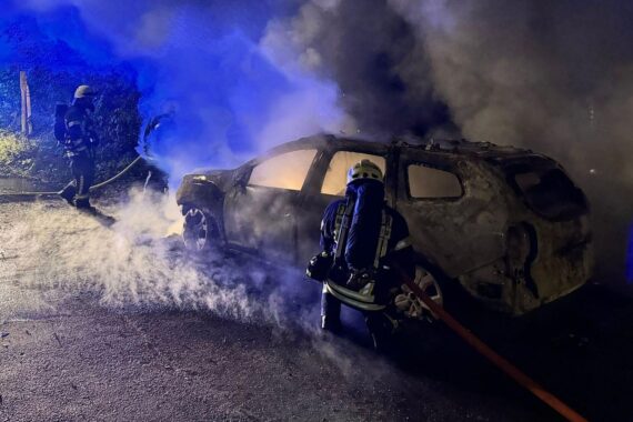 Brennender Pkw, Feuerwehr im Einsatz, Rauch und Feuer, Nachtszenario auf der Wienenbuschstraße.