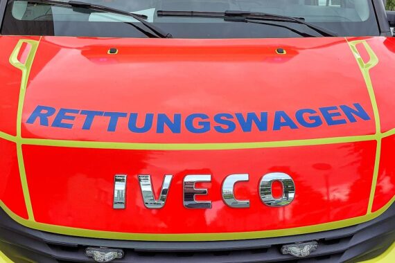 Rettungswagen an einer Unfallstelle, Fußgängerin wird nach Kollision medizinisch versorgt.