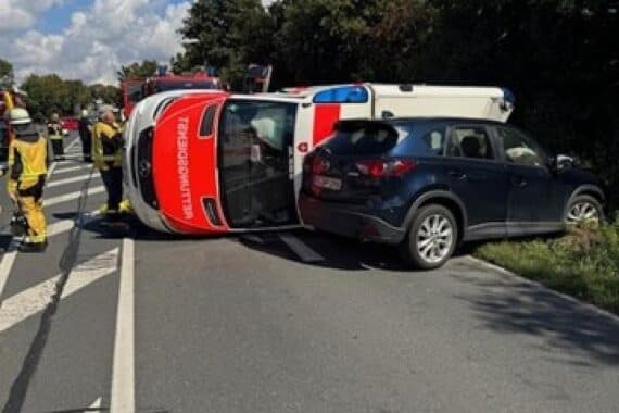 Umgekippter Rettungswagen nach Unfall, Beteiligte leicht verletzt, hoher Sachschaden.