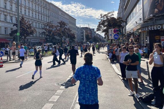 Kenianischer Marathonläufer am Ziel, jubelnde Zuschauer, Berlin-Marathon, Weltbestzeit, einzigartige Atmosphäre.