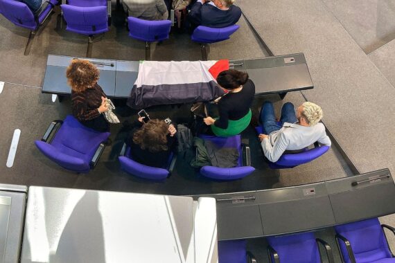 Linke Abgeordnete im Bundestag halten Palästinenserfahne, während sie aus dem Plenarsaal geworfen werden.