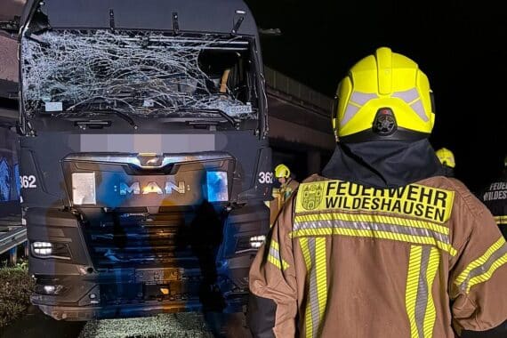 Verunfallter LKW auf Autobahn, Feuerwehr stoppt Dieselaustritt, Einsatzkräfte schützen Umwelt.