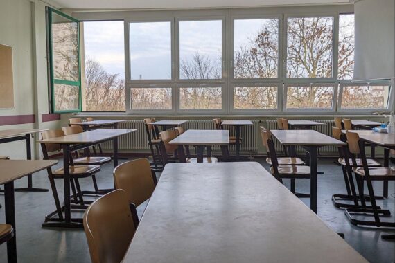 Klassenraum mit Schülern, Lehrern und digitalen Geräten, symbolisiert Bildung und Zukunftschancen 2026.