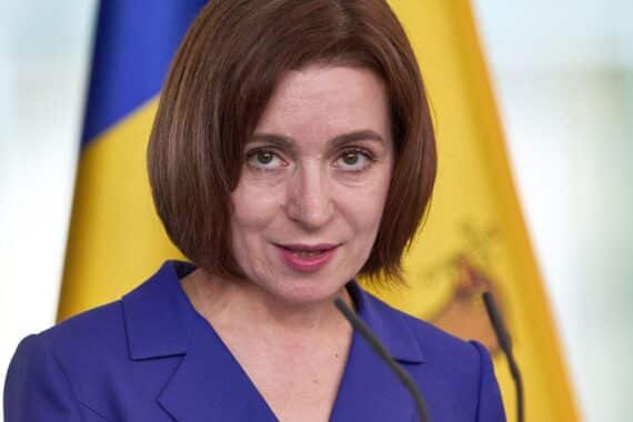 Maia Sandu steht vor dem Parlament, symbolisiert proeuropäische Einheit und Demokratie in Moldau.