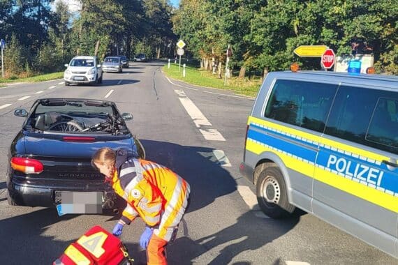 Ein schwerer Motorradunfall mit Verletzungen, beschädigten Fahrzeugen und abgesperrtem Kreuzungsbereich.