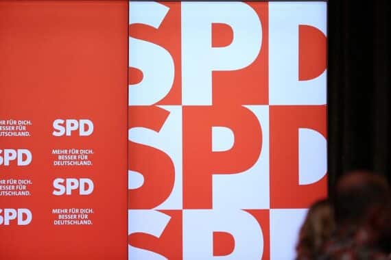 SPD-Logo vor einem Stadthorizont, symbolisiert politisches Engagement gegen vorzeitige Klimaneutralität.