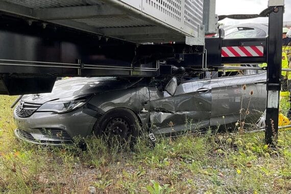Schwerer Unfall: Pkw prallt gegen Mobilfunksendemast, Rettungskräfte befreien eingeklemmte Fahrerin.
