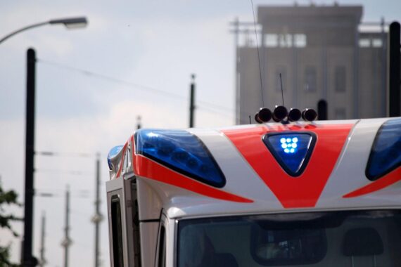 Rettungswagen am Unfallort, um verletzten Mann nach Verkehrsunfall zu transportieren.
