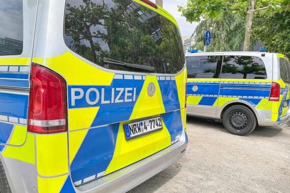 Unfallstelle mit Radfahrer und Auto, Polizei vor Ort, Rettungswagen im Einsatz.