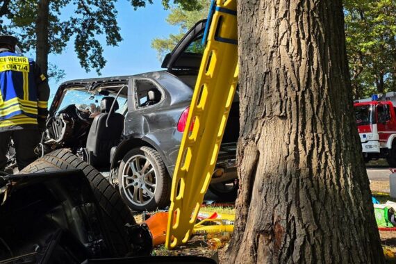 Ein schwer beschädigtes Auto, Feuerwehr im Einsatz zur Rettung eines eingeklemmten Fahrers.