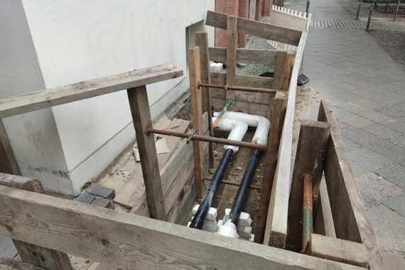 Visualisiere eine Wärmeanlage und Menschen bei einer Informationsveranstaltung zur kommunalen Wärmeplanung in Osnabrück.