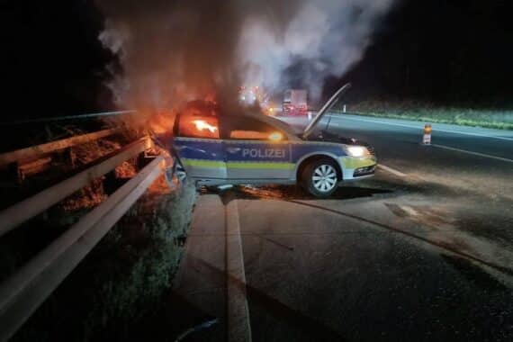 Ein ausgebrannter Polizeiwagen auf der Autobahn nach einem Verkehrsunfall mit einem BMW.